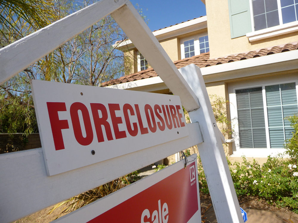 A house with a foreclosure sign in front of it.
