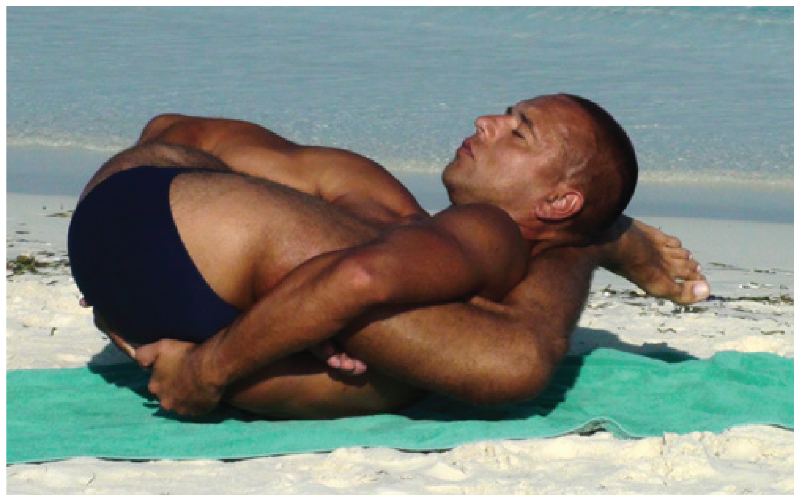 This photo shows a man executing a complicated yoga pose.