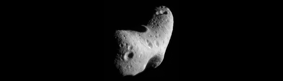 Image of the Asteroid Eros. Like nearly all asteroids, Eros is not spherical but very irregular in shape, in this case similar to a potato. The surface is pock-marked with many craters.