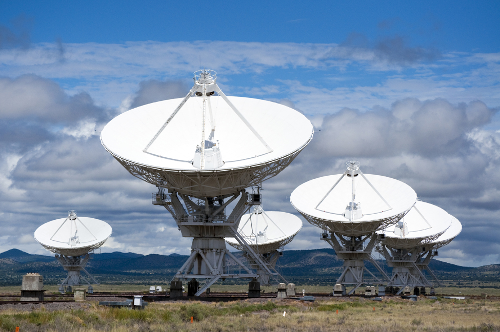 This image is a picture of radio telescopes. They have large parabolic domes as the receivers with an antenna in the center.