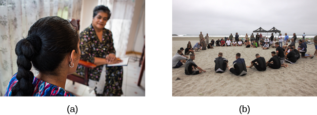 Therapy may occur (a) one-on-one between a therapist and client, or (b) in a group setting. (credit a: modification of work by Connor Ashleigh, AusAID/Department of Foreign Affairs and Trade) Two photographs are shown. Photograph A depicts two people in conversation. Photograph B depicts a large group of people sitting in a circle on the beach.