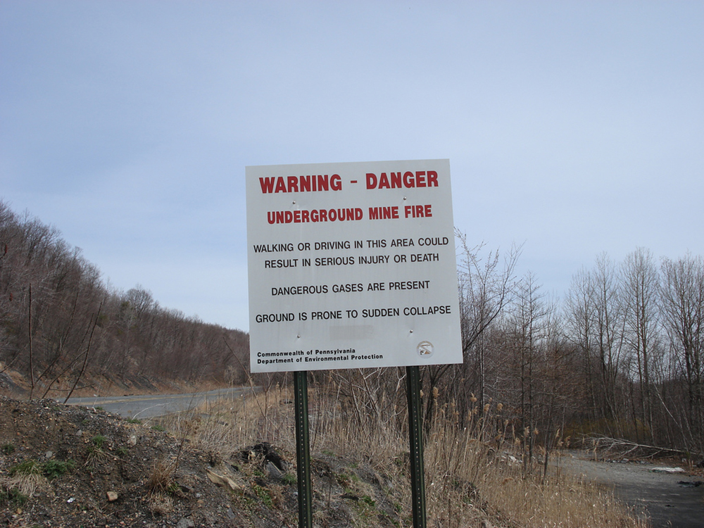 A warning sign in a field is shown here.